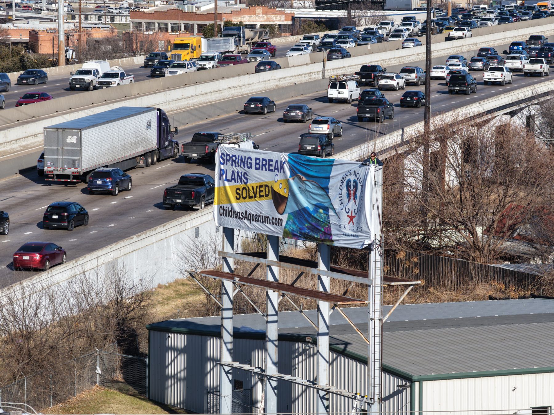 Children’s Aquarium Dallas billboard over I-30 traffic, drone photo 2